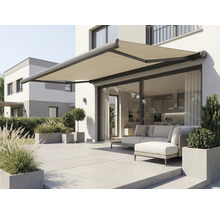 Store banne déployé sur un mur de maison au-dessus d'une terrasse avec mobilier de jardin.