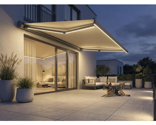 Store éclairé au-dessus d'une terrasse avec mobilier de jardin et chien