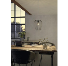 Szene mit einer Pendelleuchte aus Metall über einem Holztisch in einem hellen Raum