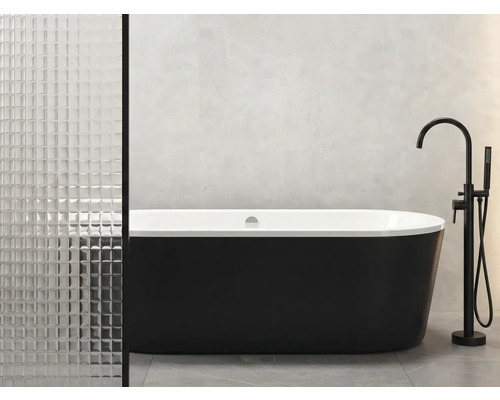 Freistehende Badewanne mit schwarzer Außenseite und weißer Innenseite neben Armatur im Badezimmer.