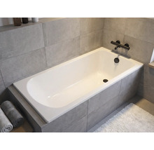 Baignoire encastrée dans une salle de bain avec robinetterie et serviettes