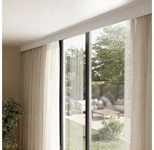 Innenraum mit Vorhängen und Blick auf eine Terrasse mit Gartenmöbeln