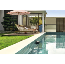 Scène avec piscine contenant un robot de piscine et deux personnes se relaxant sur des chaises longues sous un parasol