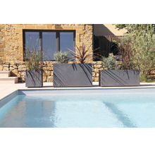 Trois bacs à plantes de tailles différentes plantés à côté d'une piscine.