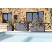 Trois jardinières grises de différentes tailles au bord de la piscine