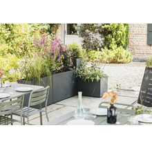 Espace extérieur avec bacs à fleurs et table de jardin sur terrasse