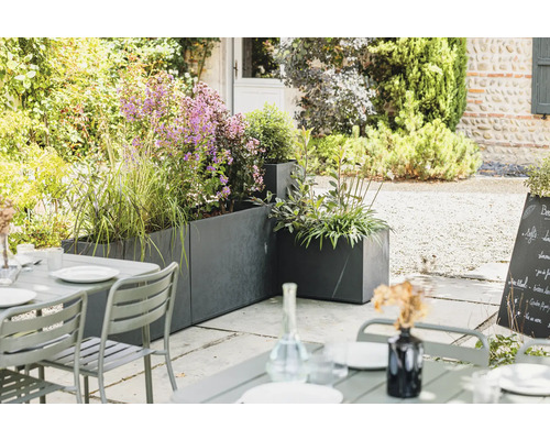 Espace extérieur avec bacs à fleurs et table de jardin sur terrasse