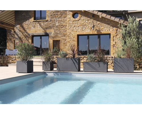 Scène avec plusieurs jardinières grises de différentes tailles à côté d'une piscine.