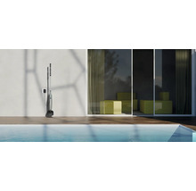 Nettoyeur de piscine à batterie sur le mur à côté de la piscine.