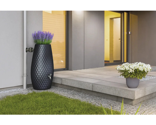 Récupérateur d'eau de pluie décoratif avec motif en losange et bac à fleurs intégré, raccordé à une descente de gouttière.