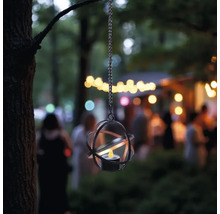 Hängende Laterne mit Metallgestell und Teelicht im Garten.