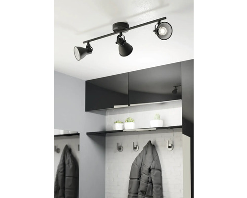 Schwarze Deckenleuchte mit drei Strahlern in einem modern eingerichteten Flur.