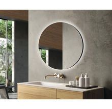 Salle de bains moderne avec miroir rond, lavabo et robinet.
