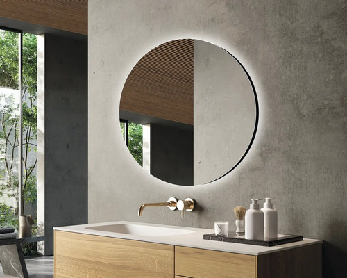 Salle de bains moderne avec miroir rond, lavabo et robinet.