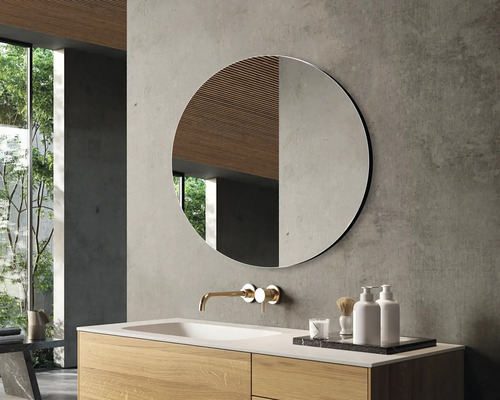 Salle de bains moderne avec miroir rond, meuble-lavabo en bois et robinetterie