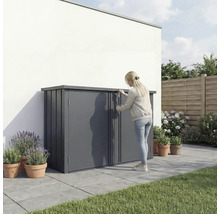 Femme ouvrant un coffre de jardin dans le jardin, pour ranger les outils et le mobilier de jardin