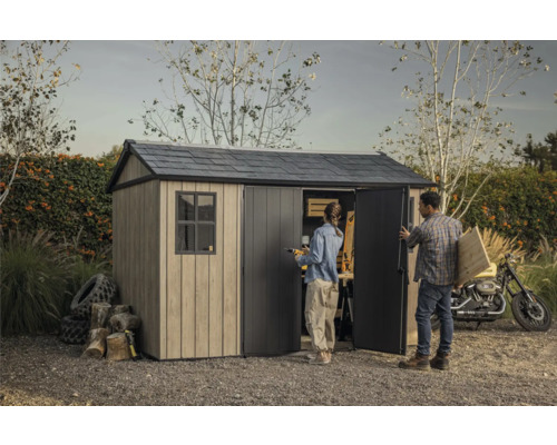 Scène de jardin avec abri de jardin, personnes, moto, bois et outils.