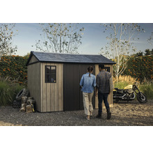 Abri de jardin avec toit à deux pans et deux personnes dans le jardin.