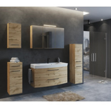 Ensemble de salle de bain moderne aspect chêne avec meuble sous vasque, armoire de toilette et colonnes sur fond gris foncé.