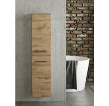 Colonne de salle de bains aspect chêne avec poignées noires sur mur en béton. En arrière-plan, mur en briques et baignoire îlot.