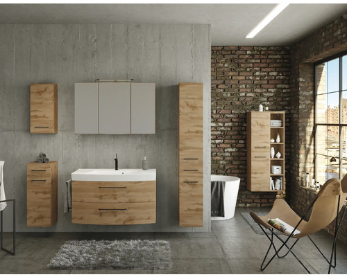 Salle de bain industrielle avec meubles aspect chêne : meuble sous-vasque, armoire de toilette et colonnes de rangement sur mur en béton.