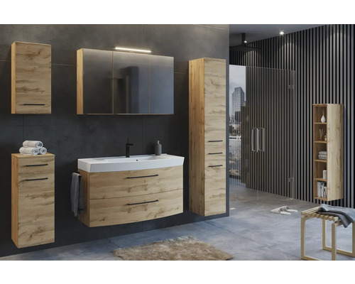 Ensemble de meubles de salle de bains aspect chêne avec lavabo, armoire de toilette avec éclairage et armoires dans une salle de bains moderne.