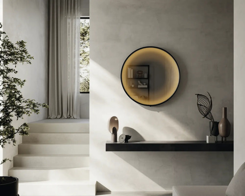 Salon lumineux avec escalier, plante, étagère murale et miroir rond éclairé