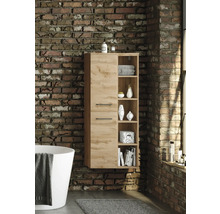 Colonne de salle de bain suspendue aspect bois avec deux portes et cinq niches ouvertes fixée sur un mur en briques à côté d une baignoire.