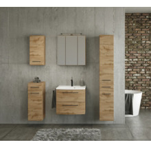 Ensemble de meubles de salle de bains aspect chêne avec meuble sous-vasque, armoire de toilette et colonne devant un mur en béton au style industriel.