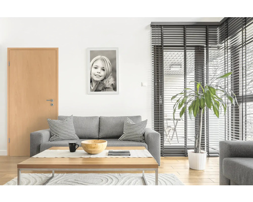 Salon avec canapé gris, table en bois et porte