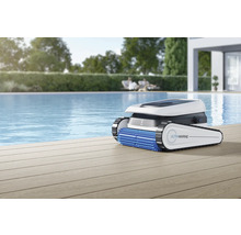 Robot de nettoyage de piscine sur terrasse en bois à côté de la piscine