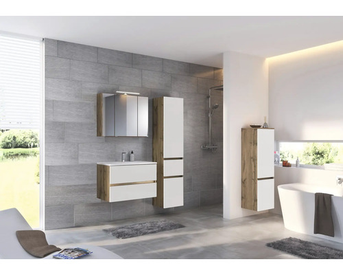 Salle de bains moderne avec ensemble de meubles blanc et aspect chêne, comprenant meuble sous-vasque, armoire de toilette et colonnes.