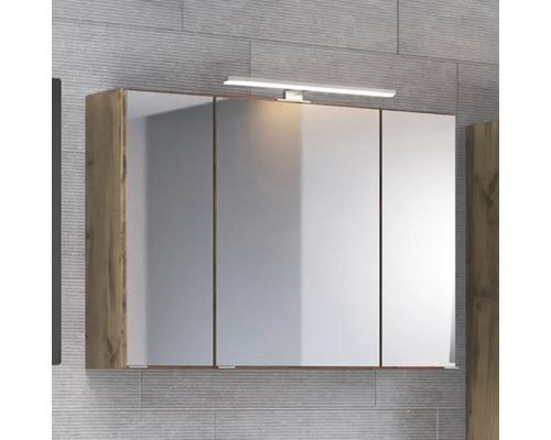 Spiegelschrank fürs Badezimmer mit drei Türen, Korpus in Eiche-Optik und LED-Aufsatzleuchte.
