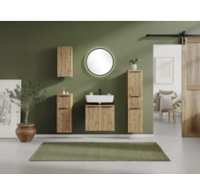 Ensemble de salle de bain moderne avec façades en lattes de bois, vasque blanche, miroir lumineux rond et colonnes de rangement suspendues.