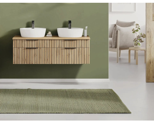 Modernes Badezimmer mit hängendem Holz-Waschbeckenunterschrank mit Lamellenfront, zwei weißen Aufsatzbecken, schwarzen Armaturen und grünem Teppich.