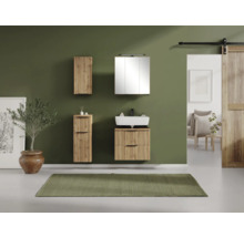 Ensemble de salle de bain moderne avec meuble sous-vasque et armoires murales aspect bois à lamelles devant un mur vert.