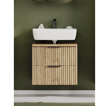 Meuble sous-lavabo mural aspect chêne avec design à lamelles, vasque à poser blanche et robinetterie noire.