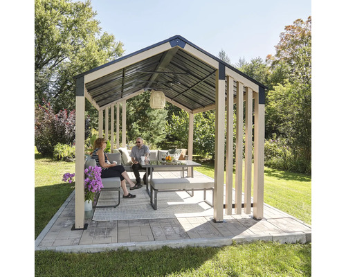 Scène de jardin avec pavillon, table et sièges sur une surface pavée