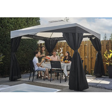 Famille prenant un repas sous un pavillon avec rideaux sur une terrasse