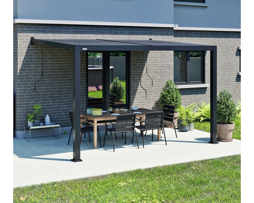 Pergola de terrasse noire avec table et chaises dans le jardin.