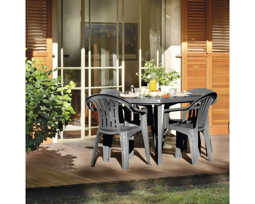 Scène de jardin avec table ronde et quatre chaises sur une terrasse en bois
