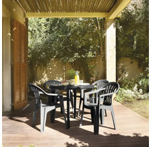 Scène de jardin avec une table de jardin noire et quatre chaises de jardin assorties sur une terrasse