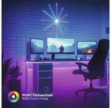 Gaming-Setup mit drei Monitoren, sternförmiger LED-Wandleuchte, LED-Streifen am Schreibtisch und RGBIC Farbwechsel-Effekt in einem dunklen Raum.