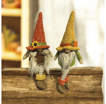 Deux gnomes d'automne décoratifs avec des chaussettes rayées assis sur du bois