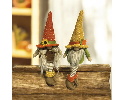 Deux gnomes d'automne décoratifs avec des chaussettes rayées assis sur du bois