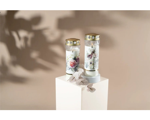 Deux bougies funéraires à motif floral sur un socle blanc