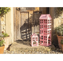 Maisons décoratives en métal de différentes tailles devant une porte d'entrée