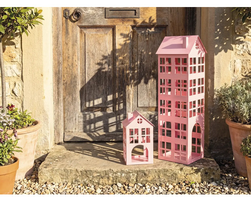 Maisons décoratives en métal de différentes tailles devant une porte d'entrée