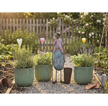 Scène de jardin avec pots plantés, lièvre en métal et décorations sur un chemin de gravier