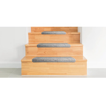 Holztreppe mit grauen Stufenmatten.